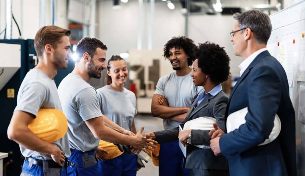 manager greeting workers in a factory.